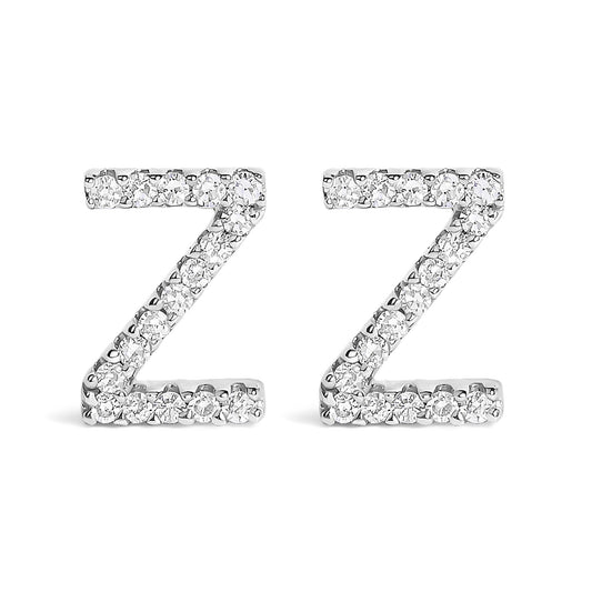Close-up front view of a pair of white metal earrings shaped like the letter Z, each adorned with small round white gemstones in a micro-pave setting.