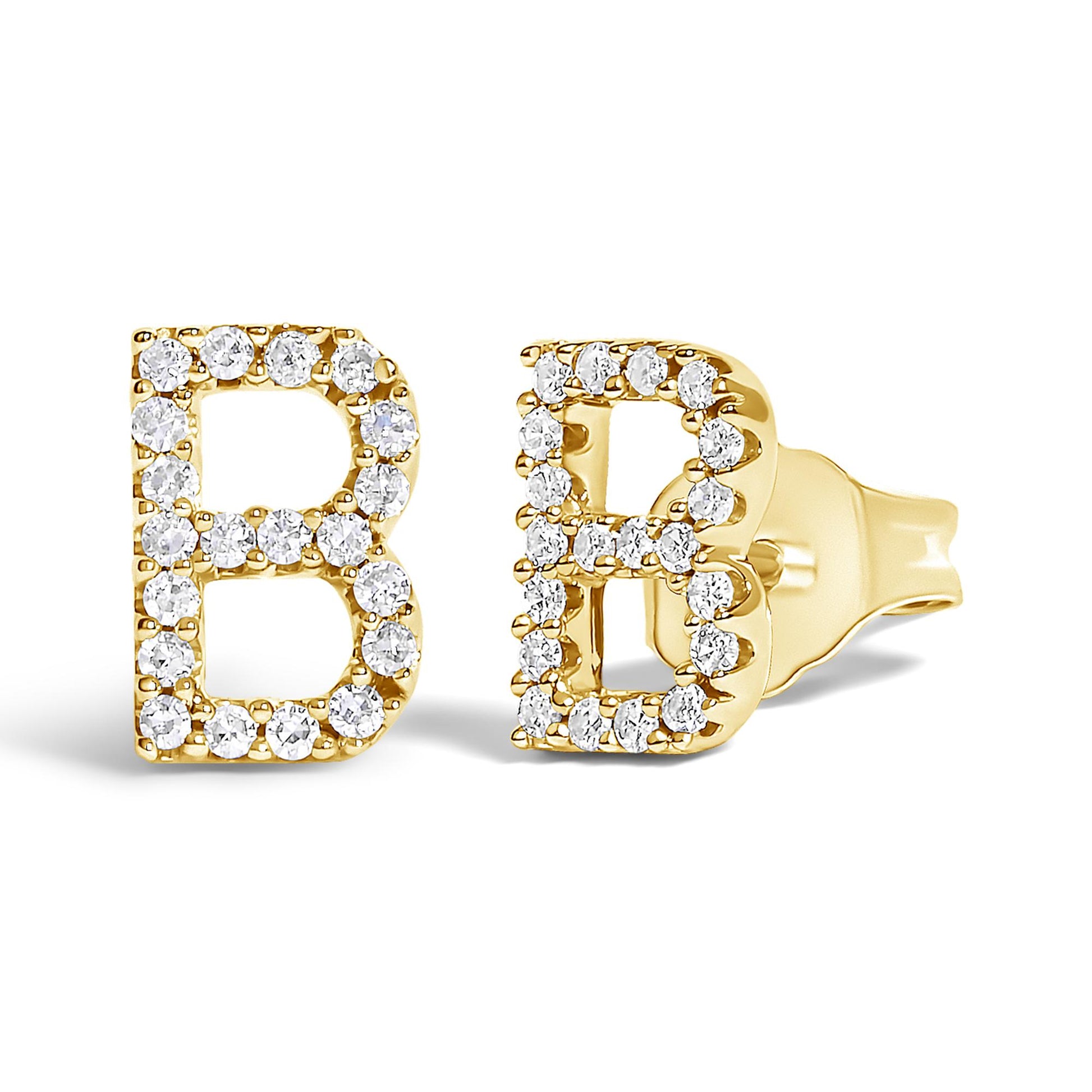 Close-up angled view of a pair of yellow metal earrings shaped as the letter B, each outlined with round white gemstones in a micro-pave setting.