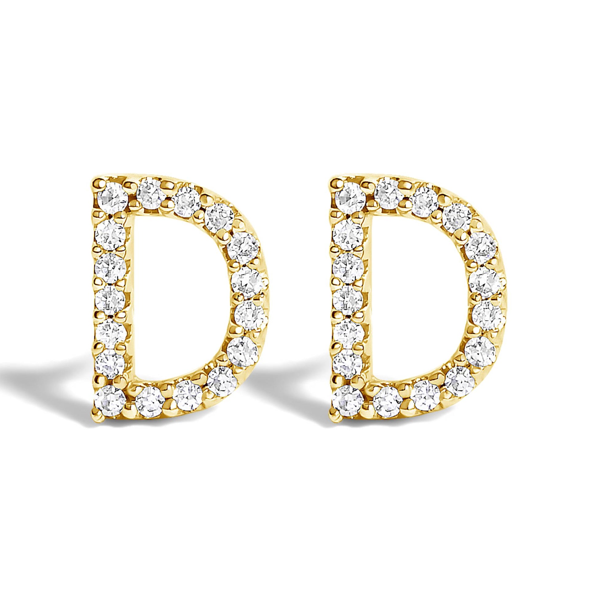 Front-facing close-up of a pair of yellow metal earrings shaped like the letter D, each outlined with small white round gemstones in a micro-pave setting.