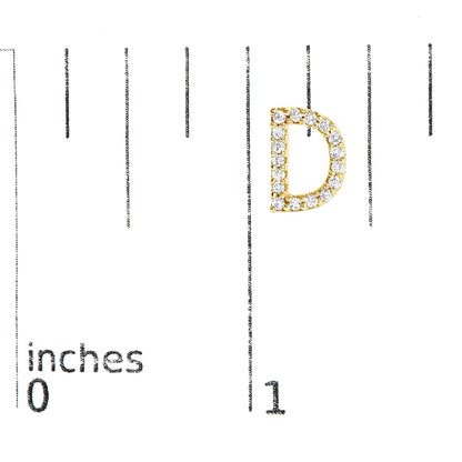 Close-up front view of a yellow metal letter D shaped earring with round white gemstones in a micro-pave setting, shown on a scale.