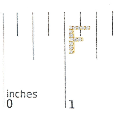 Close-up front view of a yellow metal earring shaped like the letter 'F' with round white gemstones in a micro-pave setting, shown on a scale.