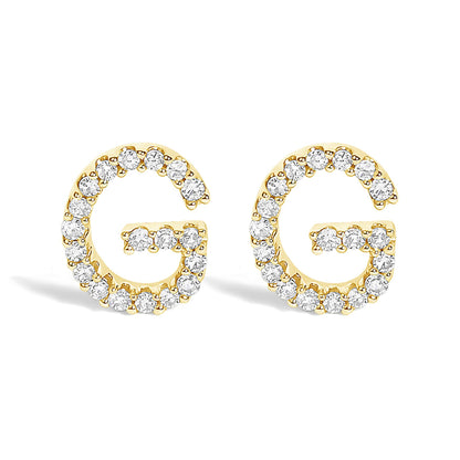 Pair of yellow metal earrings shaped like the letter G, each outlined with round white gemstones in a micro-pave setting, shown from the front angle on a white background.