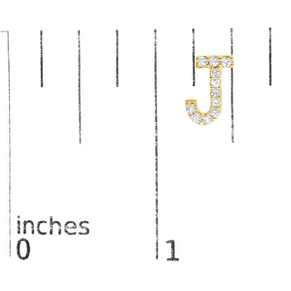 Close-up front view of a single yellow metal earring shaped like the letter J, adorned with round white gemstones in a micro-pave setting, shown on a scale.