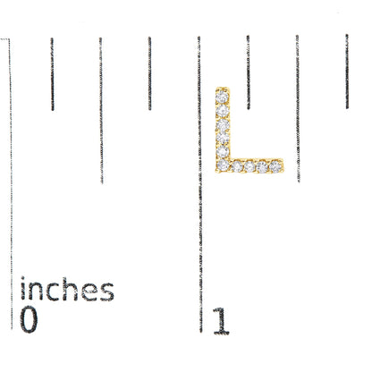 Close-up image of an L-shaped yellow metal earring with white round gemstones in a micro-pave setting, shown on a scale with inch markings, shot from the front.