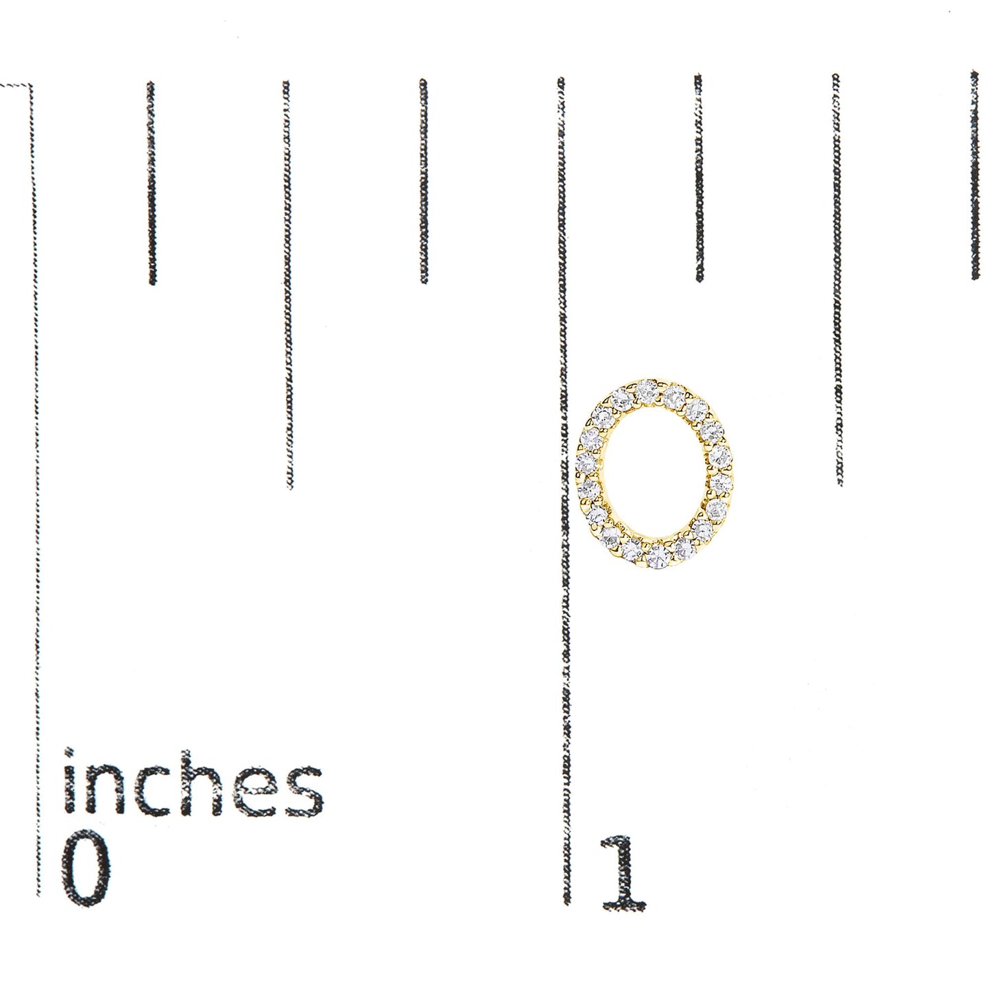 Close-up of a yellow metal oval-shaped earring with round white gemstones in a micro-pave setting, shown on a scale.