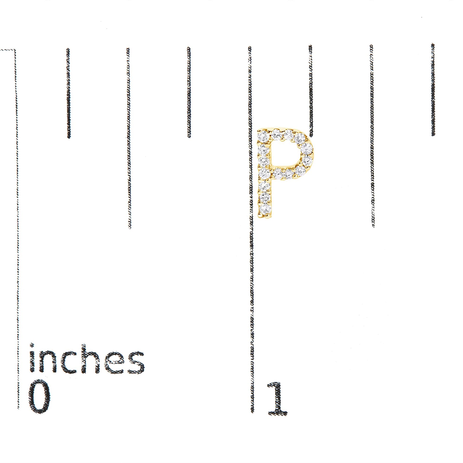 Close-up image of a yellow metal earring in the shape of the letter 'P,' adorned with white round gemstones in a micro-pave setting, shown on a scale.