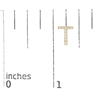 Close-up of a yellow metal letter T-shaped earring with white round gemstones in micro-pave setting, shown on a scale.