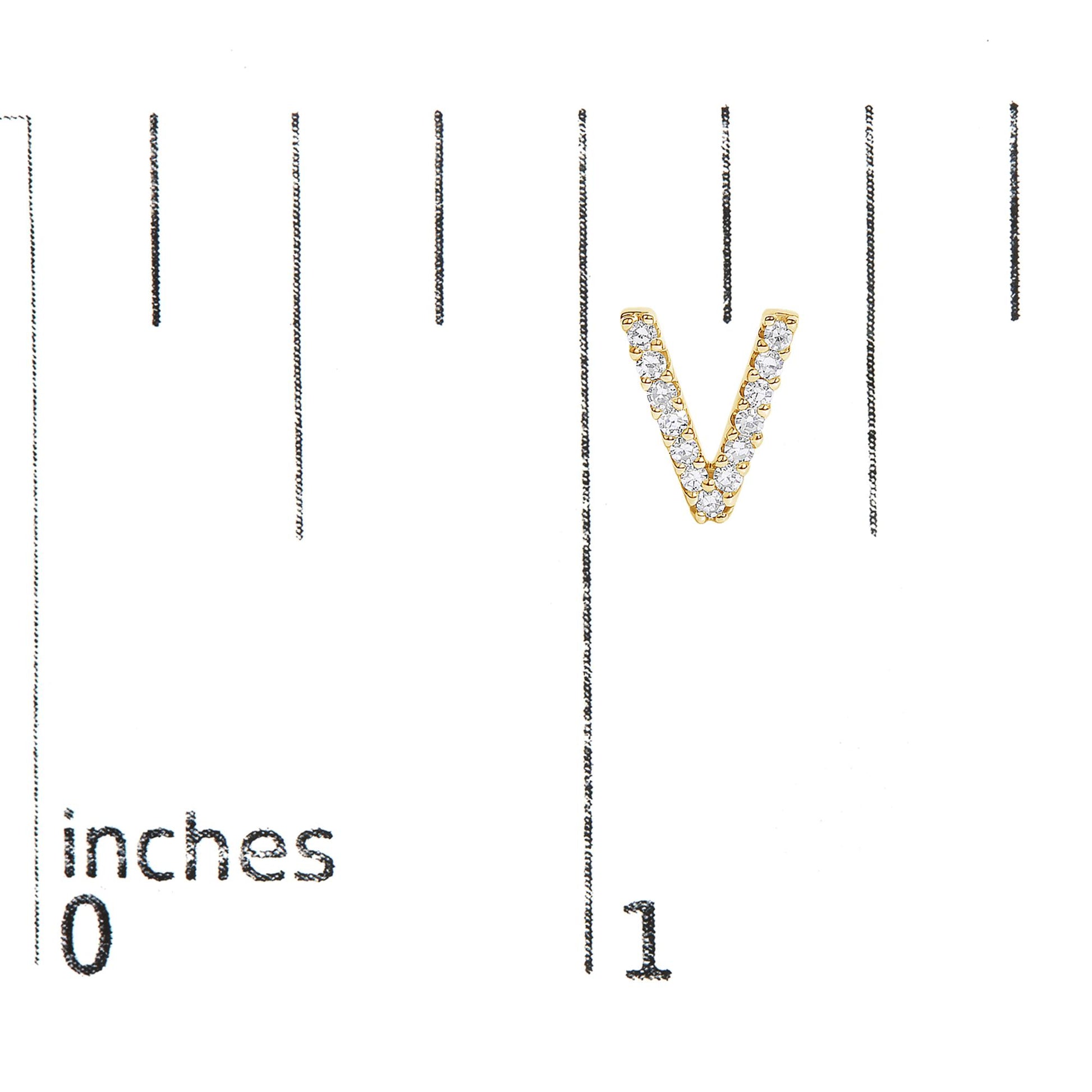 Close-up front view of a yellow metal V-shaped earring with white round gemstones in a micro-pave setting, shown on a scale.