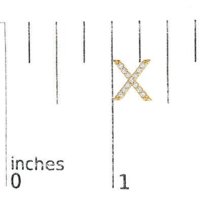 Close-up front view of a yellow X-shaped earring with round white gemstones in a micro-pave setting, shown on a scale.