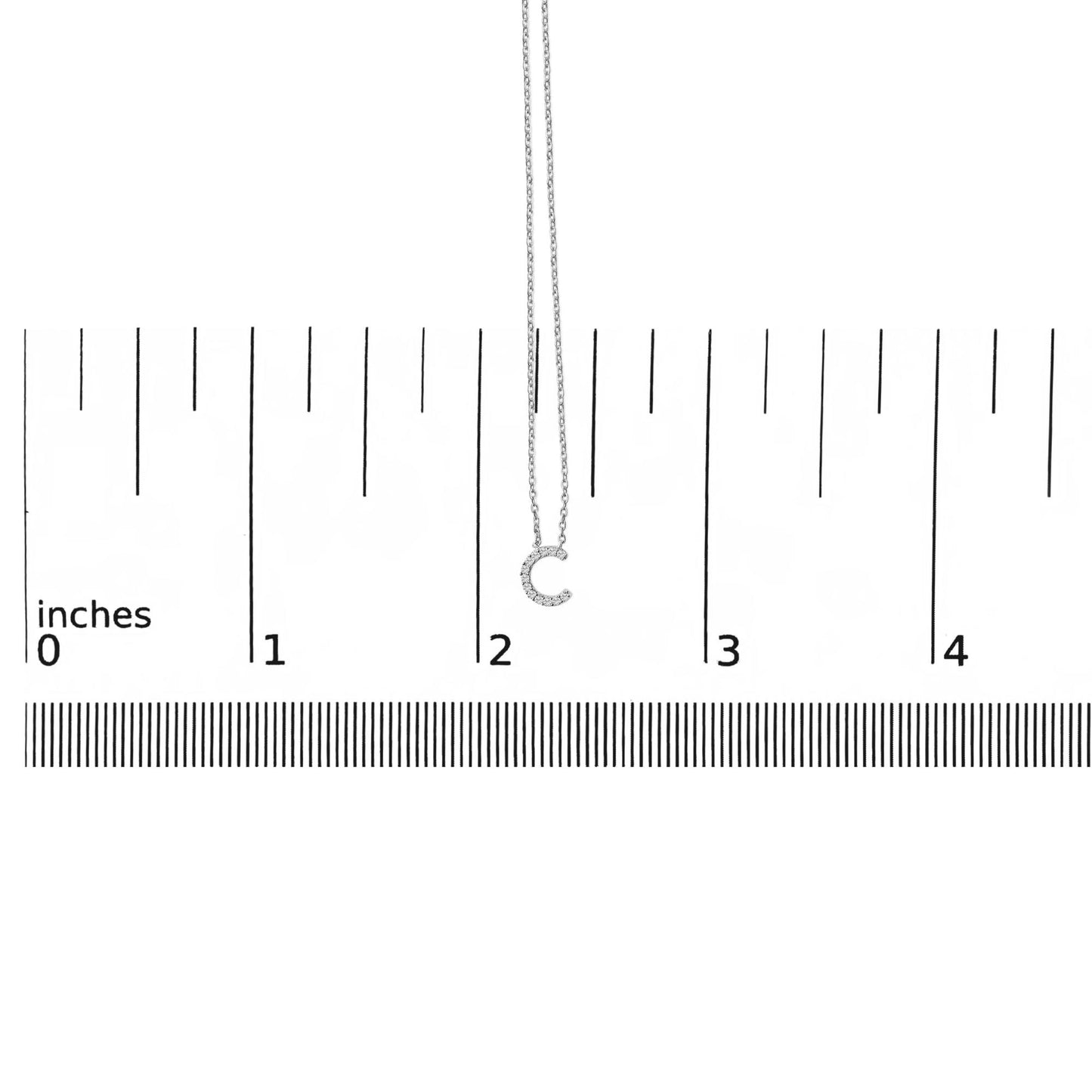 White necklace with a pendant shaped like the letter C, covered in white gemstones, shown on a scale from a front angle.