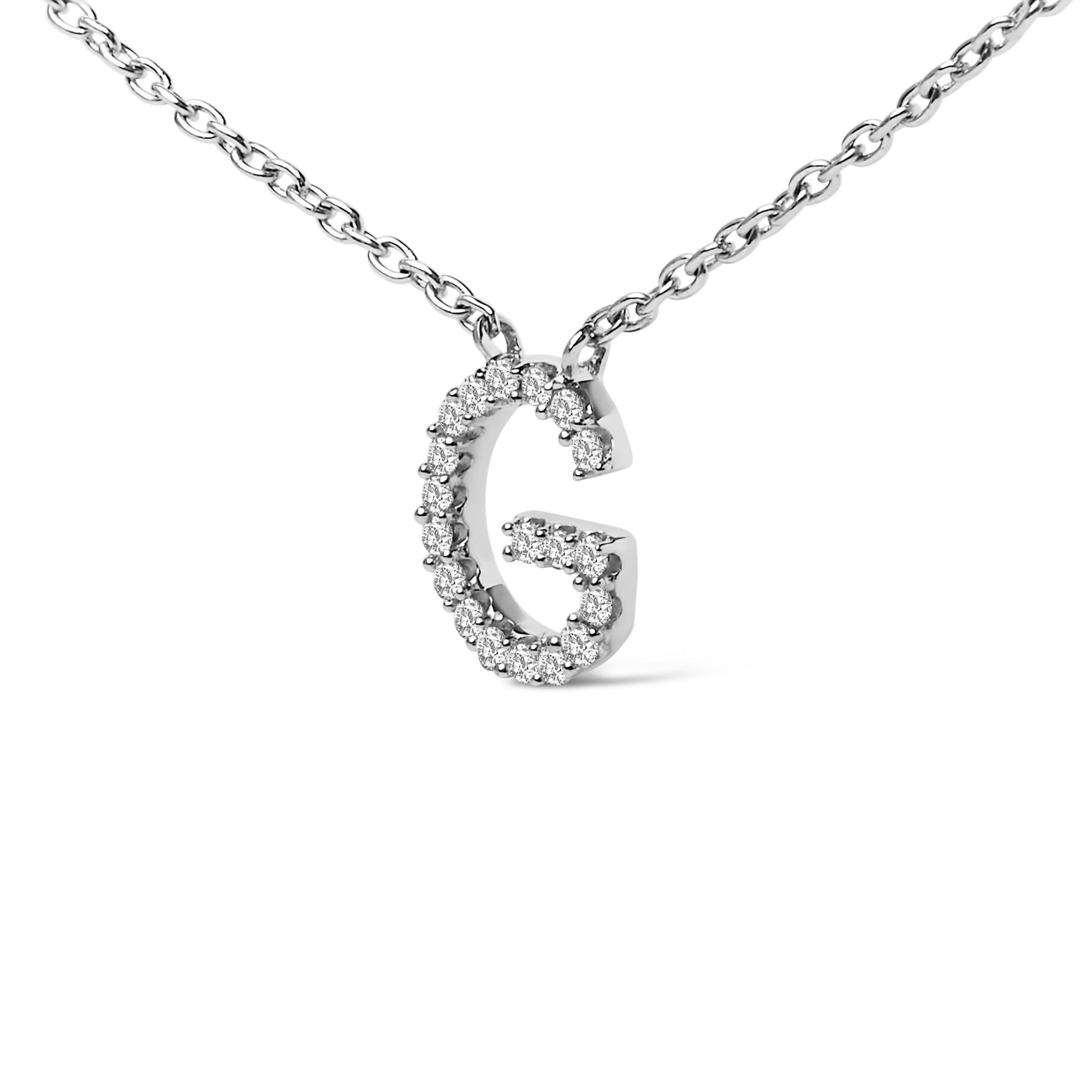 Close-up front angle of a white metal necklace with a 'G' shaped pendant adorned with small round white gemstones in a micro-pave setting.
