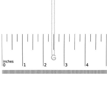 Close-up front view of a white necklace chain with a pendant shaped like the letter G, encrusted with small white gemstones, shown on a ruler scale.
