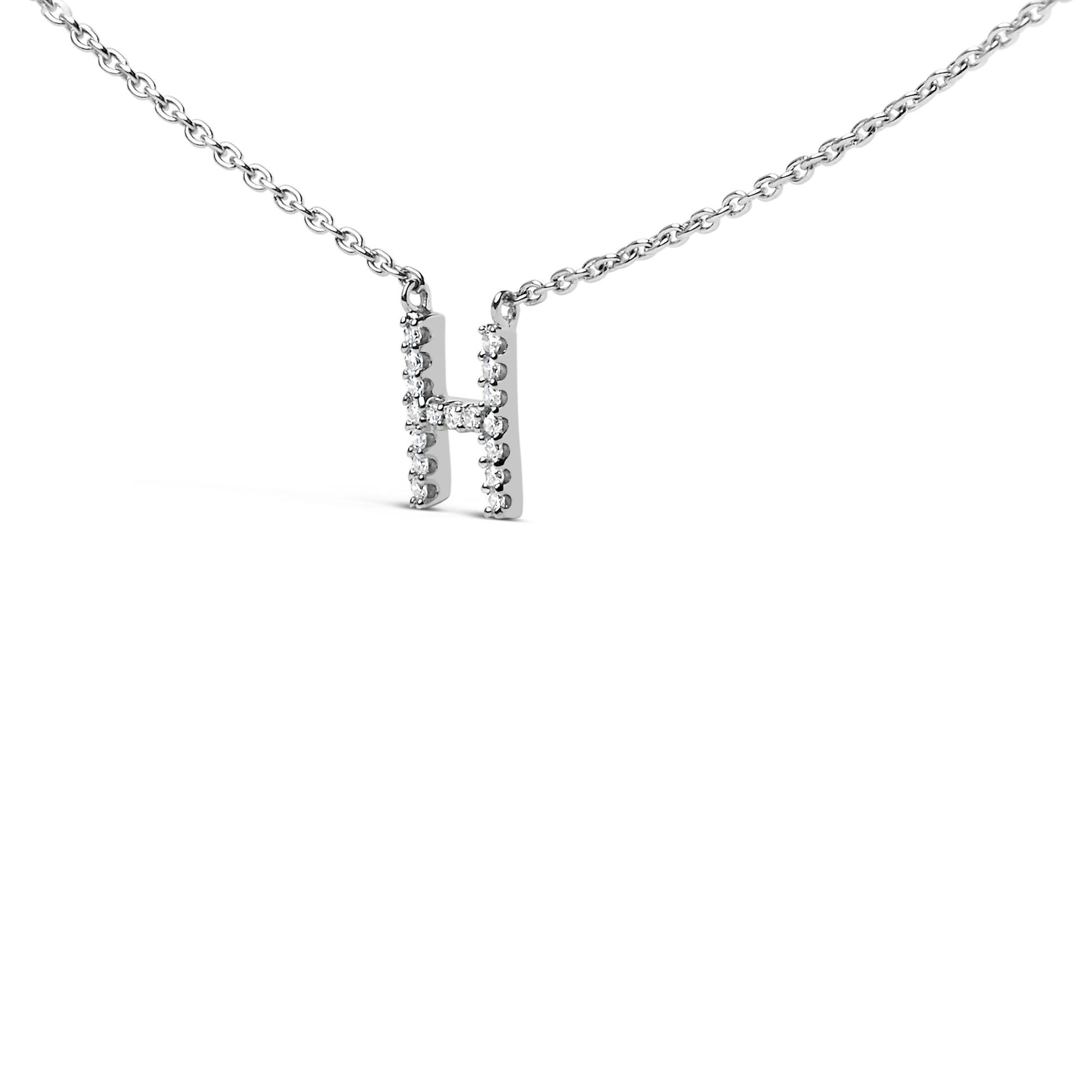 Close-up front angle of a white metal necklace with a pendant shaped like the letter 'H' adorned with round white gemstones in micro-pave setting.