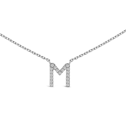 Close-up front angle of a white necklace with a chain and a pendant shaped as the letter 'M' encrusted with round white gemstones in a micro-pave setting.