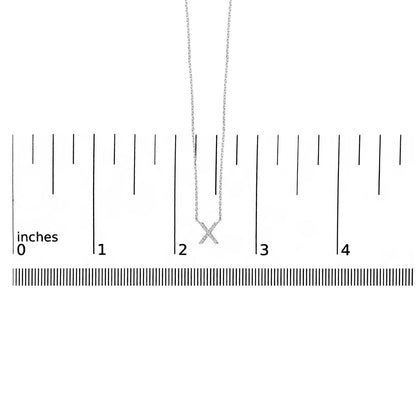 White necklace with an 'X' pendant featuring round white gemstones in a micro-pave setting, shown hanging vertically on a scale, front view.