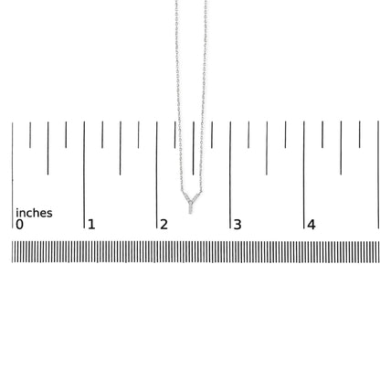 White metal necklace with Y-shaped pendant featuring small round white gemstones in micro-pave setting, shown hanging on a ruler scale from a front angle.