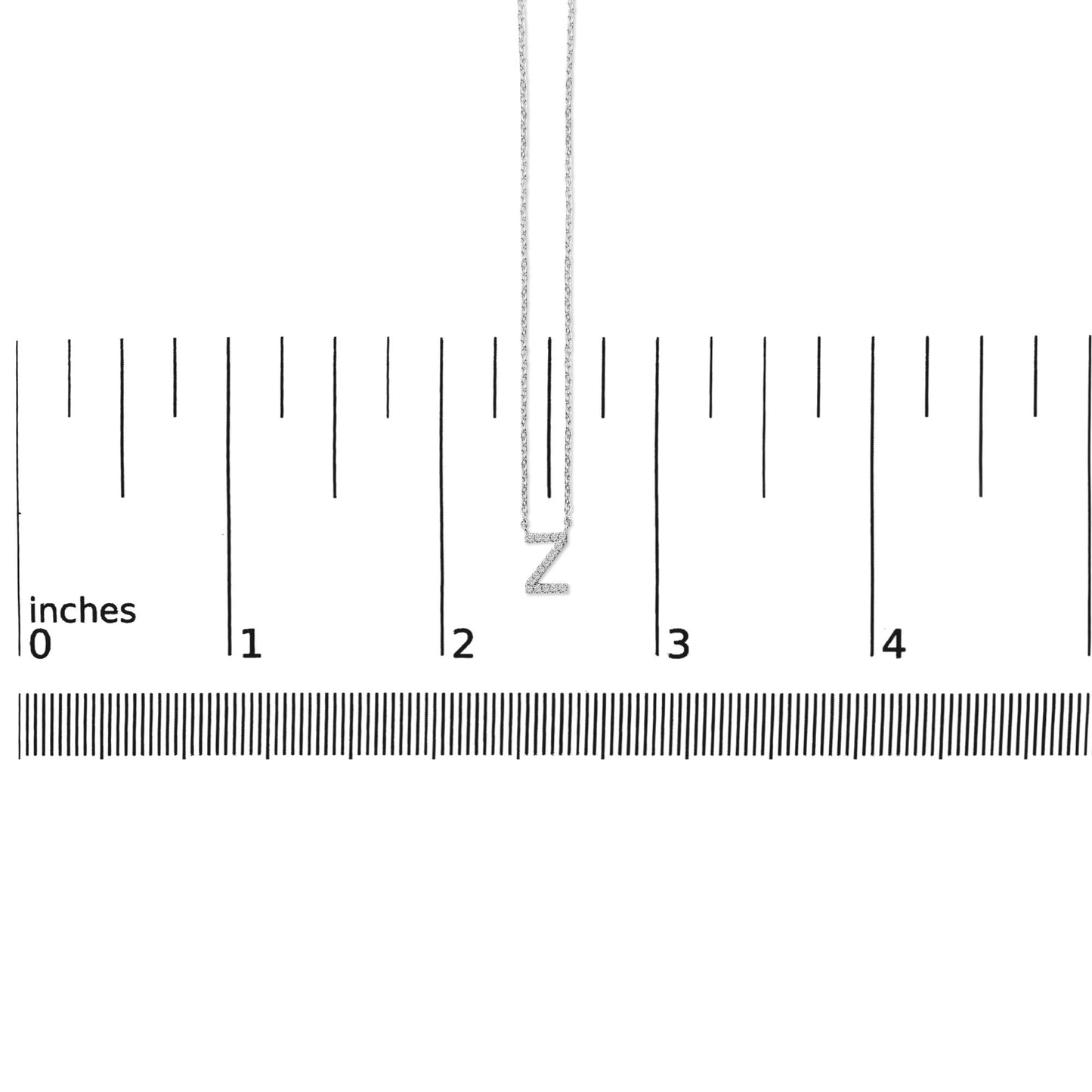 White metal necklace with a Z-shaped pendant set with small white gemstones, shown hanging vertically on a ruler scale, front view.