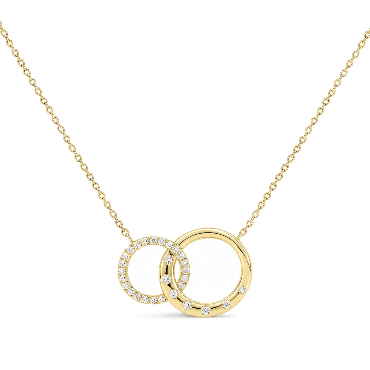 Close-up front view of a yellow metal necklace with two interlocking circular pendants, one adorned with white gemstones in prong settings and the other with scattered white gemstones, shown on a white background.