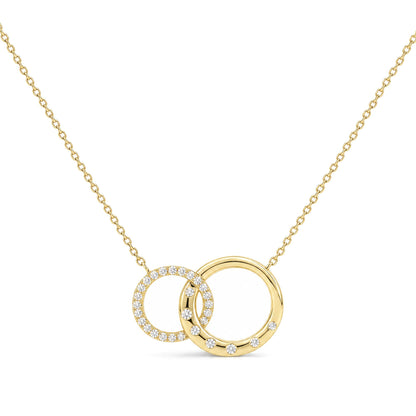 Close-up front view of a yellow metal necklace with two interlocking circular pendants, one adorned with white gemstones in prong settings and the other with scattered white gemstones, shown on a white background.