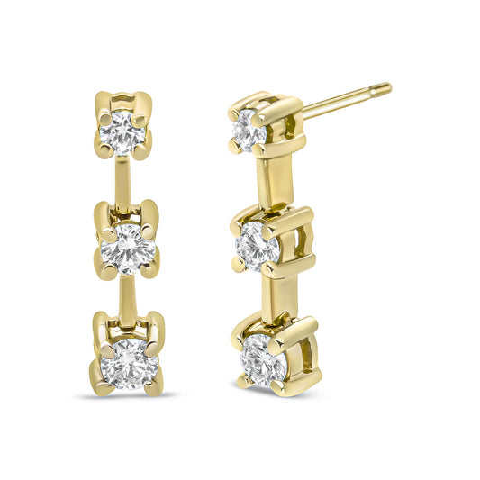 Front and side view of yellow metal earrings with three vertically aligned white gemstones in prong settings.