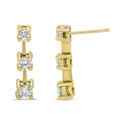 Pair of yellow metal earrings with three round white gemstones in prong settings, shown from front and side angles.