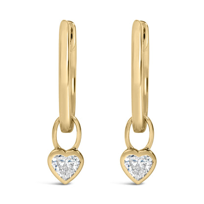 Close-up front view of a pair of yellow metal earrings featuring dangling heart-shaped charms with white gemstones in bezel settings.