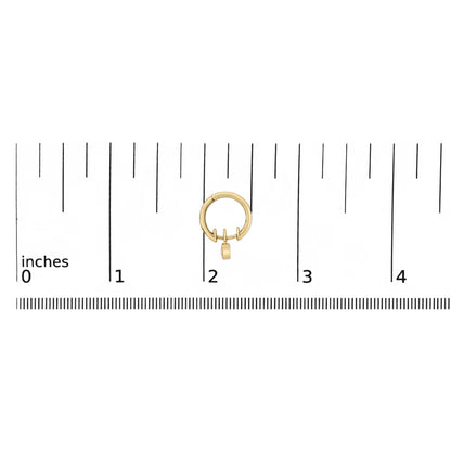 Close-up front view of a single yellow metal hoop earring with a small dangling piece featuring a white heart-shaped gemstone in bezel setting, shown on a ruler scale background.