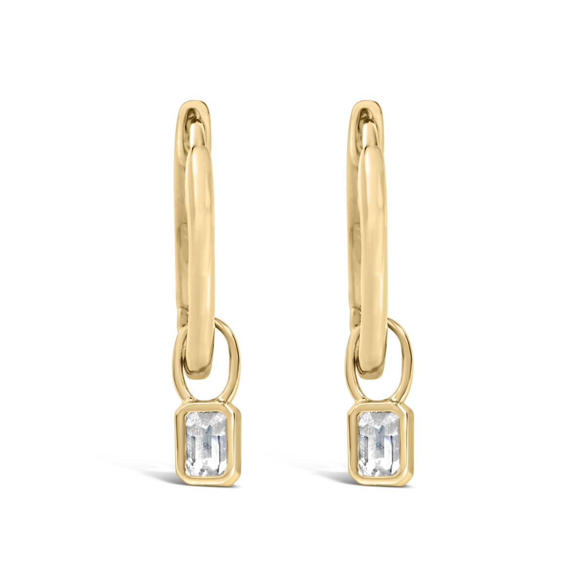 Front angle close-up of yellow metal drop earrings featuring linked oval shapes and bezel-set white emerald-shaped gemstones at the bottom.