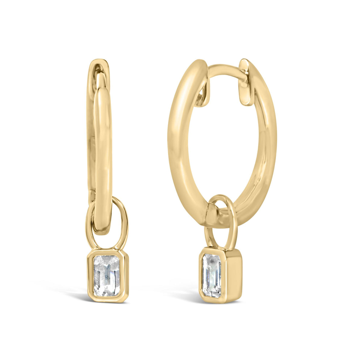 Close-up front angle of a pair of yellow metal hoop earrings with a small connected rectangular pendant featuring a white gemstone in a bezel setting.