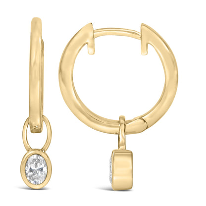 Close-up front and side view of yellow metal hoop earrings with oval white gemstones in bezel setting hanging from the hoops.