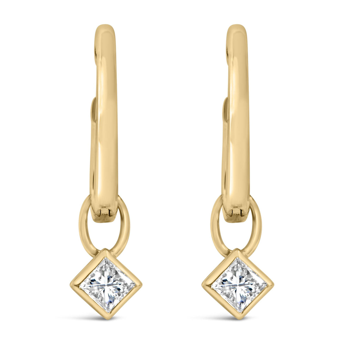 Pair of yellow metal earrings shown in close-up front view, featuring dangling princess-shaped white gemstones in bezel settings.