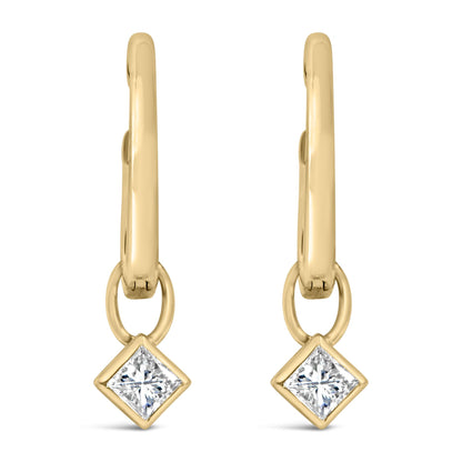 Pair of yellow metal earrings shown in close-up front view, featuring dangling princess-shaped white gemstones in bezel settings.