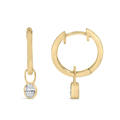 Close-up front and side view of yellow metal hoop earrings with oval white gemstones in bezel settings, shown on a white background.