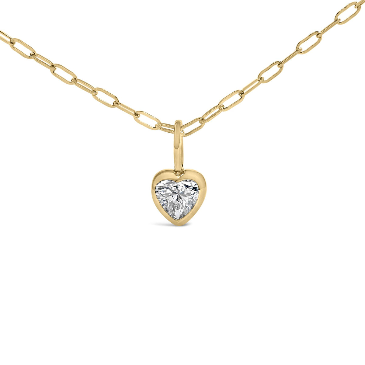 Front view of 14K yellow gold heart pendant necklace with paperclip chain and bezel-set solitaire diamond on white background