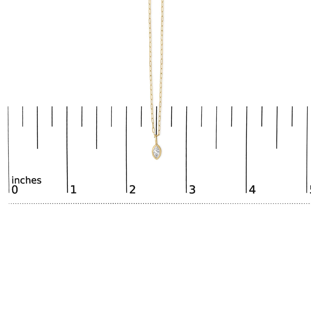 Close-up front view of a yellow necklace with a marquise-shaped white gemstone in a bezel setting, shown on a scale.