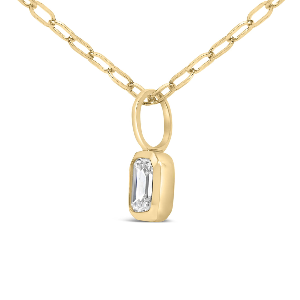 Close-up front-angle image of a yellow metal necklace featuring a chain link and a pendant with a single white emerald-shaped gemstone set in a bezel setting.