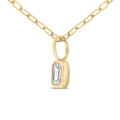 Close-up front-angle image of a yellow metal necklace featuring a chain link and a pendant with a single white emerald-shaped gemstone set in a bezel setting.