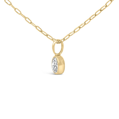 Front view of 14K yellow gold oval diamond bezel-set solitaire pendant necklace showcasing paperclip chain with white background