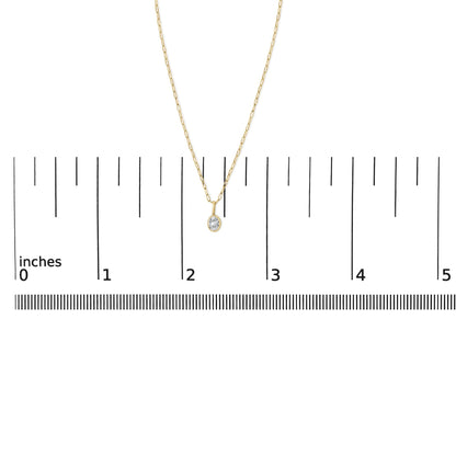 Close-up front view of a yellow necklace with a pendant featuring one oval white gemstone in a bezel setting, shown on a scale.