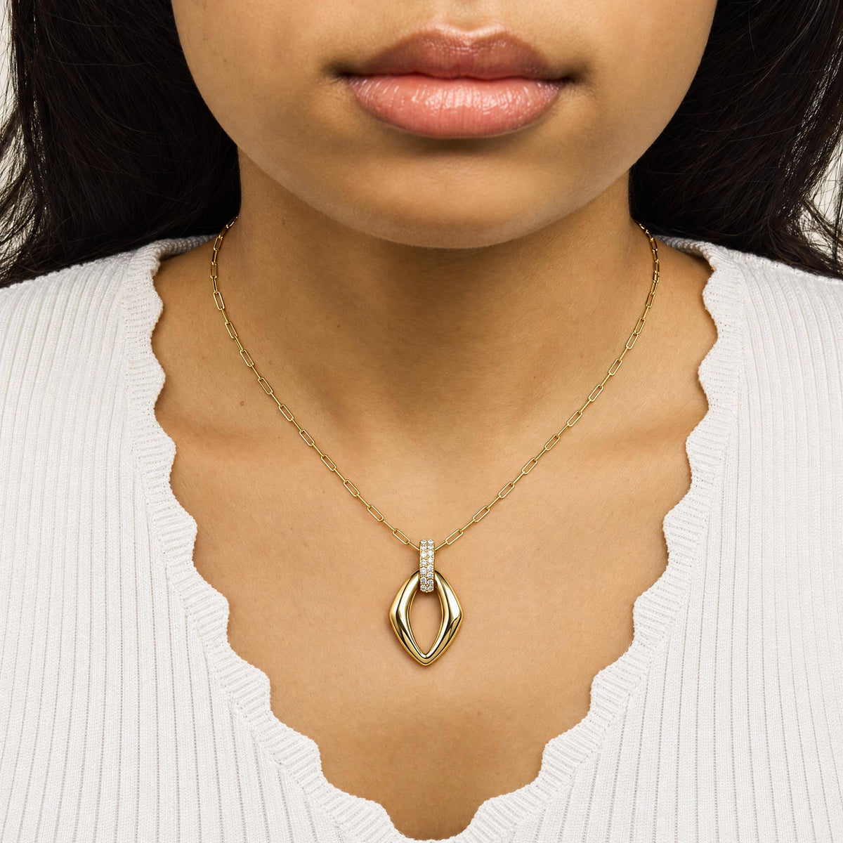 Close-up front view of a model wearing a yellow necklace with a geometric pendant adorned with white round gemstones in a prong setting.