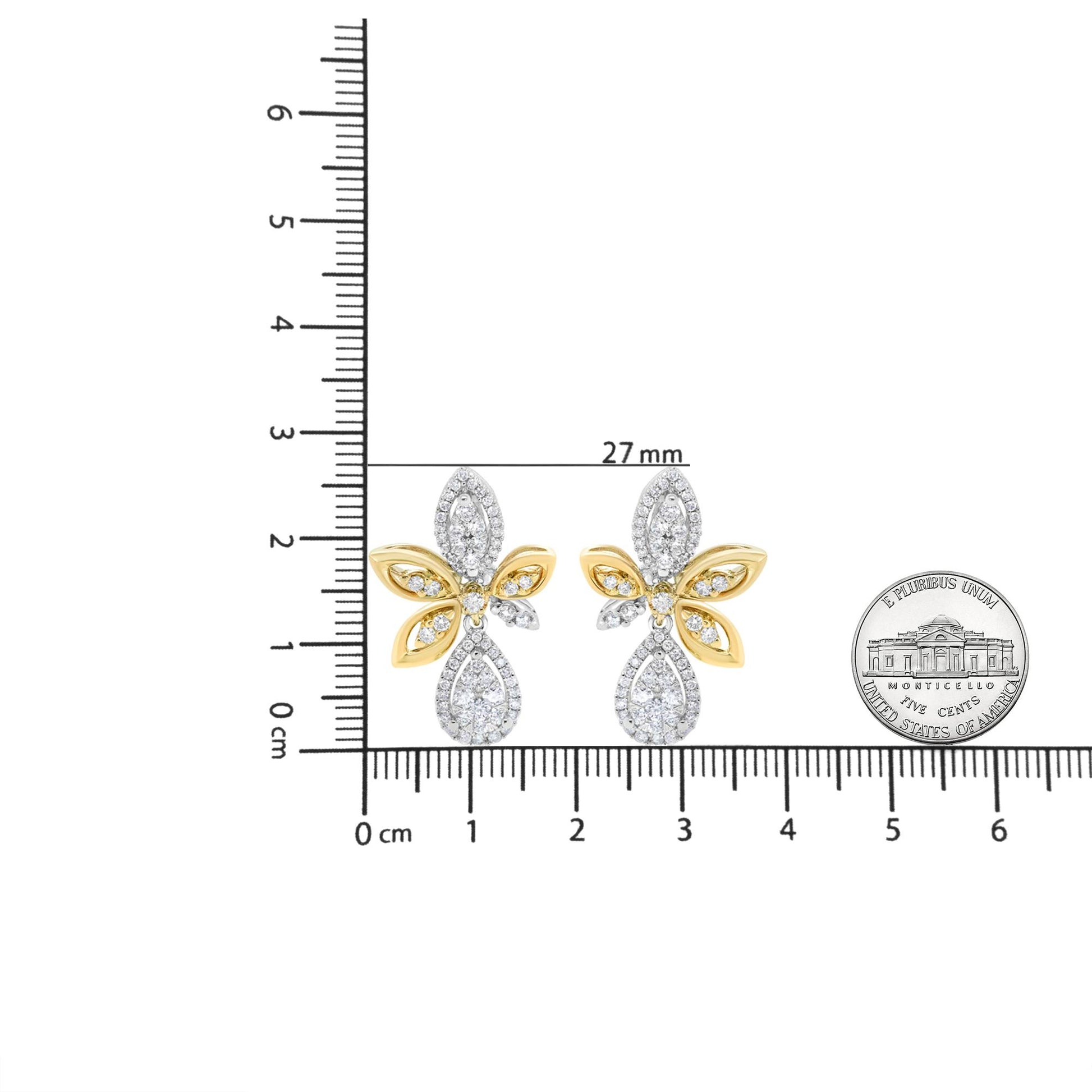 Pair of yellow and white metal earrings with round white gemstones in pave setting, shaped like teardrops and petals, placed on a ruler for size reference, front-facing angle.
