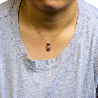 Close-up front view of a rose metal necklace on a model, featuring a pendant with pave-set round white gemstones and pave-set round brown gemstones.