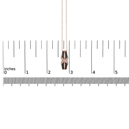 Rose metal necklace with a pendant featuring white and brown round pave-set gemstones, displayed on a ruler for size reference, front-facing angle.