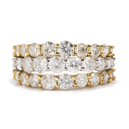 Close-up front angle of three stacked rings with yellow and white metal bands, each set with round white gemstones in a prong setting. Rings are shown on a reflective surface.