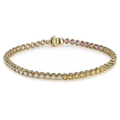 Close-up image of a yellow metal bracelet with round white gemstones and multicolored round gemstones in prong settings, shown laid flat in a partial circle from a top angle.