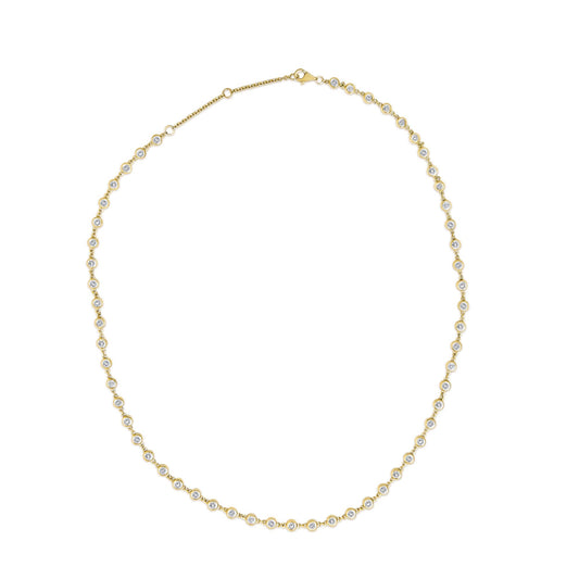Close-up top view of a yellow metal necklace with round white gemstones in bezel settings along the chain, shown on a white background.