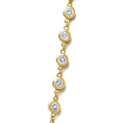 Close-up front view of a yellow necklace featuring multiple round white gemstones in bezel settings connected by small links, shown on a white background.