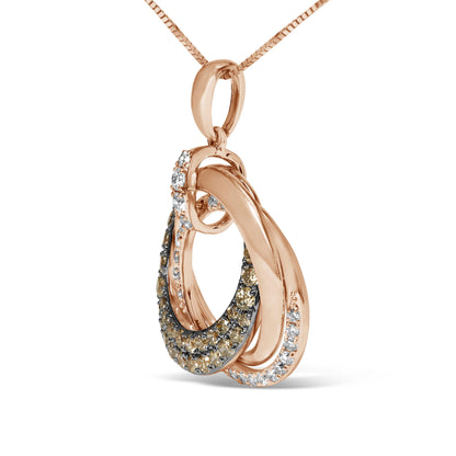 Close-up angled view of a rose-colored metal necklace pendant featuring two interlocking loops, one adorned with pave-set white gemstones and the other with pave-set brown gemstones.