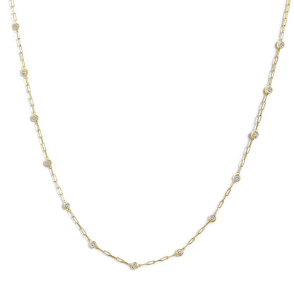Yellow metal necklace with linked chain and round white gemstones in bezel settings, shown in a flat lay, close-up angle.