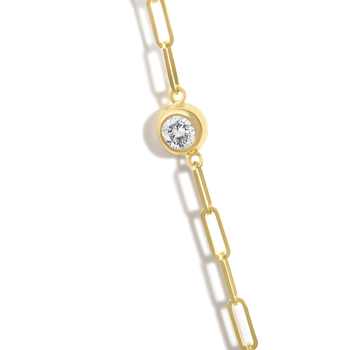 Close-up front view of a yellow metal necklace chain with a round white gemstone in a bezel setting.